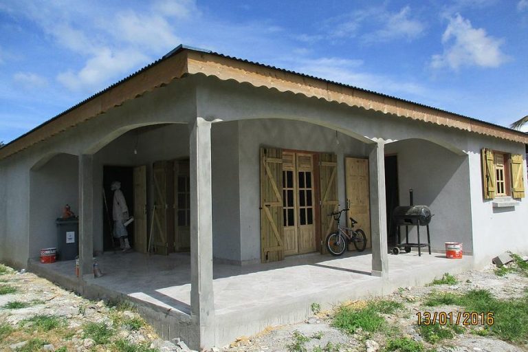 Maison de plain-pied en travaux avec terrasse couverte et menuiseries en bois